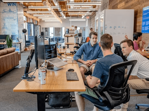 Team collaborating in a modern office with code on screen